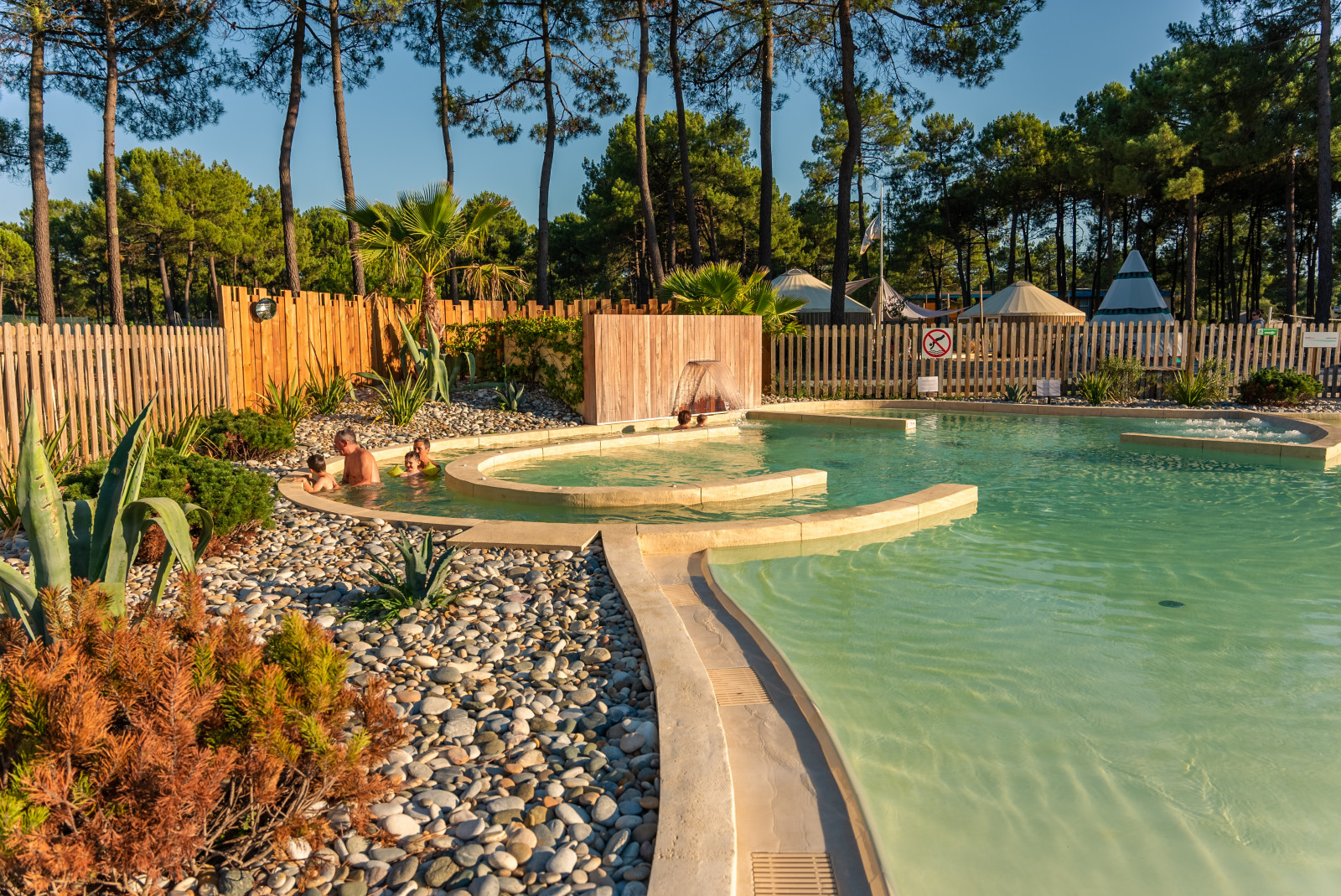 enfants et grand-parents en train de jouer à la piscine naturiste