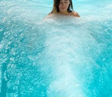 Femme dans une piscine à jets sous-marin. Espace marin de la thalasso d'Euronat.